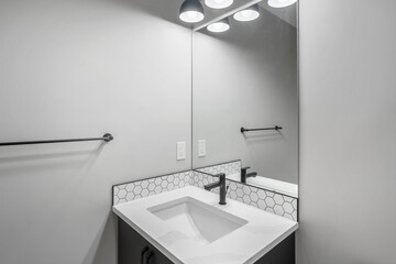 Bathroom with a white sink and black towel rack