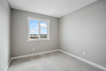 Very clean and empty bedroom with a large window
