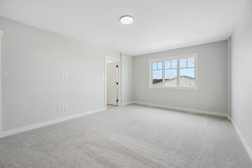 Large, empty room with a window and a light fixture