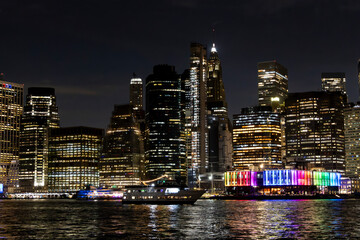 Obraz premium Illuminated skyline of New York City at night showcasing colorful lights along the waterfront