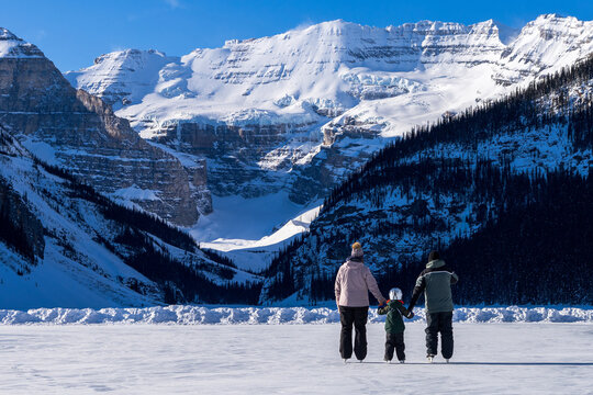 A family skating on Lake Louise winter ice skating rink. Banff National Park, Canadian Rockies. Alberta, Canada.