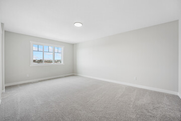Large, empty room with a window and a light fixture