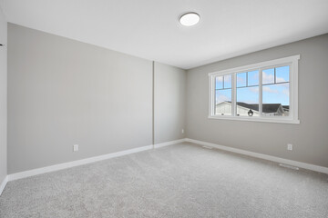Large, empty room with a window and a light fixture