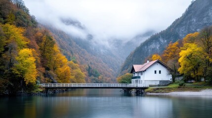 Autumnal mountain chalet by a serene lake. Misty valley, colorful foliage, and a tranquil bridge lead to a secluded white house