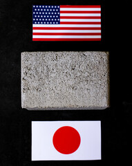 Concrete block between USA and Japan Flags symbolizes challenges and friction United States and...