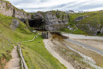 Smoo Cave in the Scottish Highlands captivates with its wide coastal opening and water-carved...