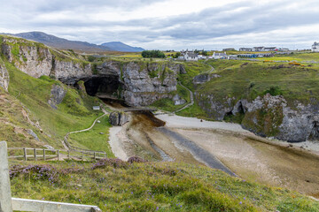 Smoo Cave in the Scottish Highlands captivates with its wide coastal opening and water-carved...
