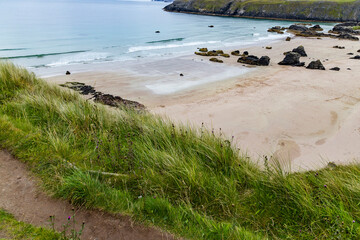 Panoramic viewpoint above Durness Beach, powerful waves crash against golden sand and striking rocks rise along the shore. A wild, breathtaking coastal scene in the heart of the Scottish Highlands.