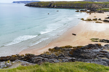 Panoramic viewpoint above Durness Beach, powerful waves crash against golden sand and striking rocks rise along the shore. A wild, breathtaking coastal scene in the heart of the Scottish Highlands.