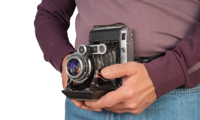 Vintage camera held by person outdoors in casual attire showcasing love for photography