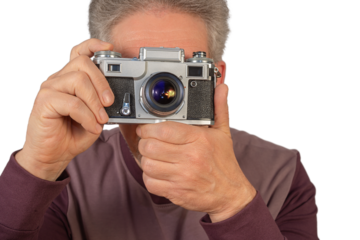 Man holding a vintage camera and preparing to take a photograph, isolated on transparent background
