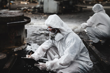 Workers in safety suits check chemicals in an old factory during a radiation emergency.