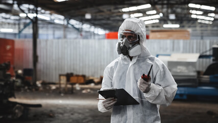 Workers in safety suits check chemicals in an old factory during a radiation emergency.