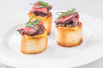 Grilled baguette sandwich with melted cheese, juicy steak, caramelized onions, and rosemary