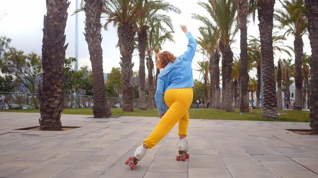 Happy young woman roller skating  and dancing outdoor in the city.