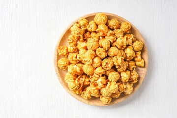  Caramel  popcorn  in wooden plate on white background t ,Snack	
