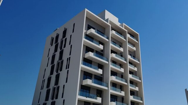 Full View White Color Building With Black Windows And Blue Sky Background.
Highrise Tower or Sky Scraper, Building Outdoor Exterior View With Balcony And Terrace PentHouse Apartment
Top Floor Building