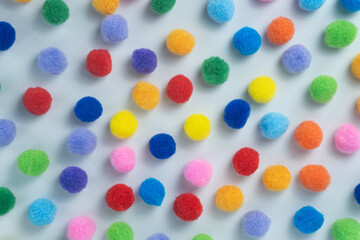 Colorful Fluffy Pom Poms Scattered on White Background