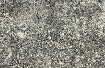 Close-up of coarse concrete surface with embedded pebbles and granular texture in muted gray tones evoking urban resilience, material analysis and editorial realism