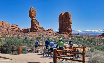 Bicycle tourists stop for a photo of Balanced Rock in Utah's Arches National Park