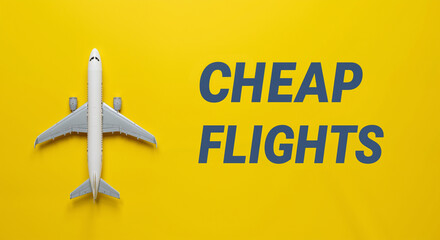 Fototapeta premium Airplane model with cheap flights text on yellow background 