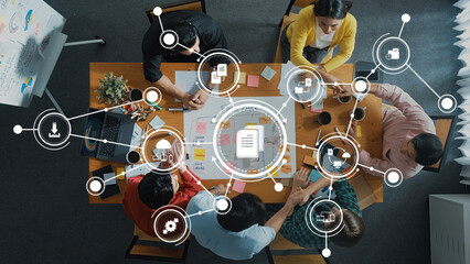 A dynamic overhead view of a diverse team engaged in collaborative management strategies, utilizing...