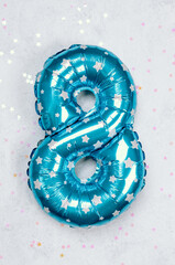 Bright blue star-patterned balloon shaped like number eight for celebrations