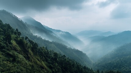 A serene view of misty mountains showcasing lush green hills under a cloudy sky.