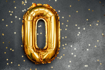 Celebration decor featuring a golden number zero and scattered stars
