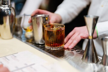 Crafting a perfect cocktail at a bustling city bar during evening hours
