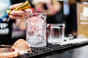 Crafting a refreshing cocktail with precision at a lively bar event