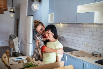 Happy lesbian couple embracing in new home while moving in