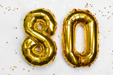 Celebrate 80th birthday with golden balloons and confetti for a joyful occasion