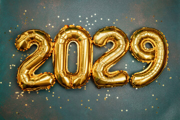 Bright golden balloon numbers celebrating New Year’s Eve in 2029 with confetti