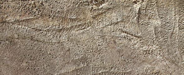 An old grey wall texture, background. Coarse concrete view. Ancient gray surface, backdrop. Rough, uneven surface in grey color with abstract pattern. An old concrete slab, weathered, faded with time