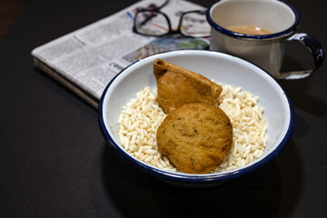 Puffed rice in a bamboo basket with Samosa, a crispy and spicy Indian triangle shape snack with tea, spectacles and newspaper in the morning, creating a warm and nostalgic ambiance