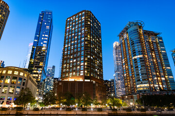 Business skyscraper at night. Skyscraper in city downtown. City architecture. Office building in business district. Modern glass building. Chicago night city. Night cityscape of Chicago skyscraper