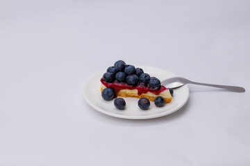 Start your morning right with a luscious blueberry sheet cake, crowned with fresh blueberries and served alongside rich black coffee.