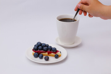 Start your morning right with a luscious blueberry sheet cake, crowned with fresh blueberries and served alongside rich black coffee.