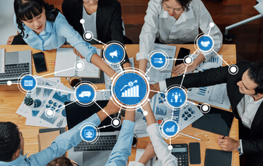 A vibrant scene depicting a business team engaged in collaboration around a table with various data charts, laptops, and documents, emphasizing teamwork and strategic planning. Amity