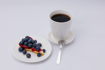 Start your morning right with a luscious blueberry sheet cake, crowned with fresh blueberries and served alongside rich black coffee.