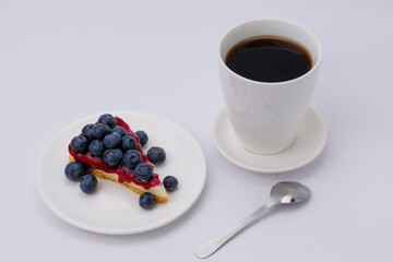 Start your morning right with a luscious blueberry sheet cake, crowned with fresh blueberries and served alongside rich black coffee.
