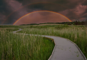 Boardwalk with rainbow on the horizon