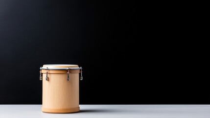 Wooden drum on a light surface against a black backdrop