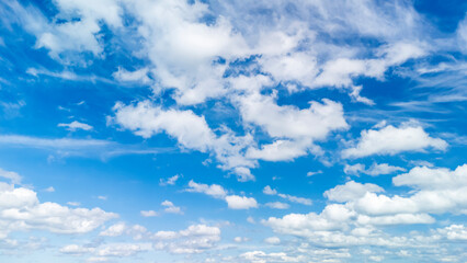 Fototapeta premium Bright blue sky filled with white fluffy clouds, creating a serene and uplifting atmosphere suitable for various projects, including nature themes and backgrounds.