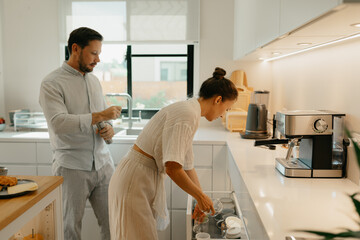 A couple is making coffee in the kitchen