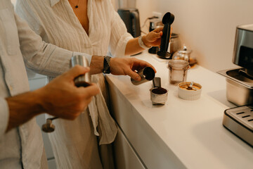 A couple is making coffee in the kitchen