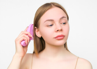 Naklejka premium Woman brushing her hair with a pink brush 
