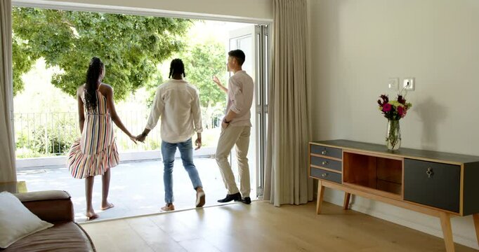 Real estate agent showing african american couple around a new house