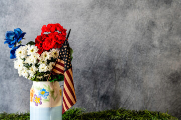 red white and blue spring flowers with American flag on grey background with room for copy